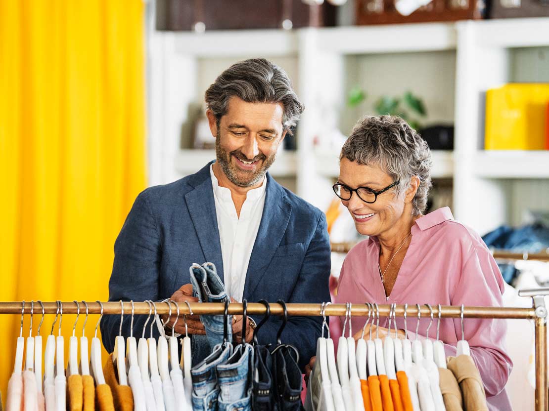 Man och kvinna i klädbutik som tittar på ett par jeans