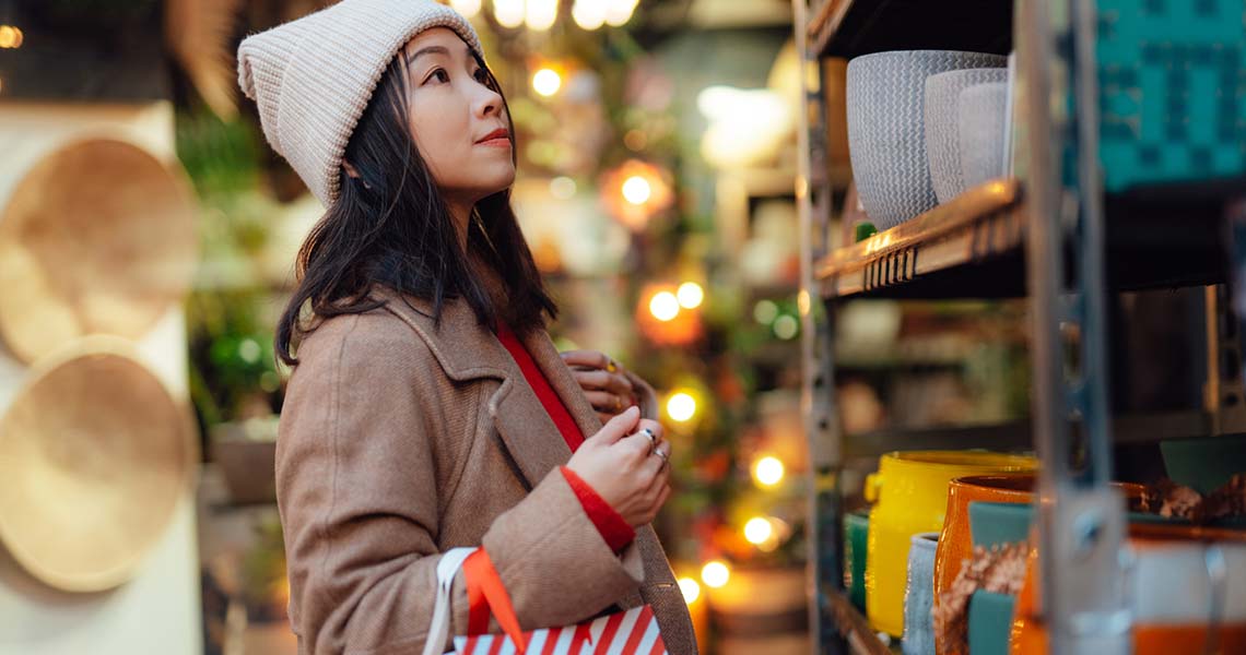 Kvinna med påse julhandlar i butik