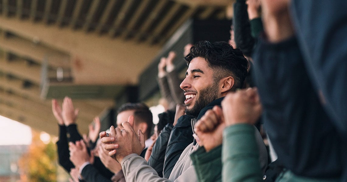 Publik på fotbollsmatch som applåderar