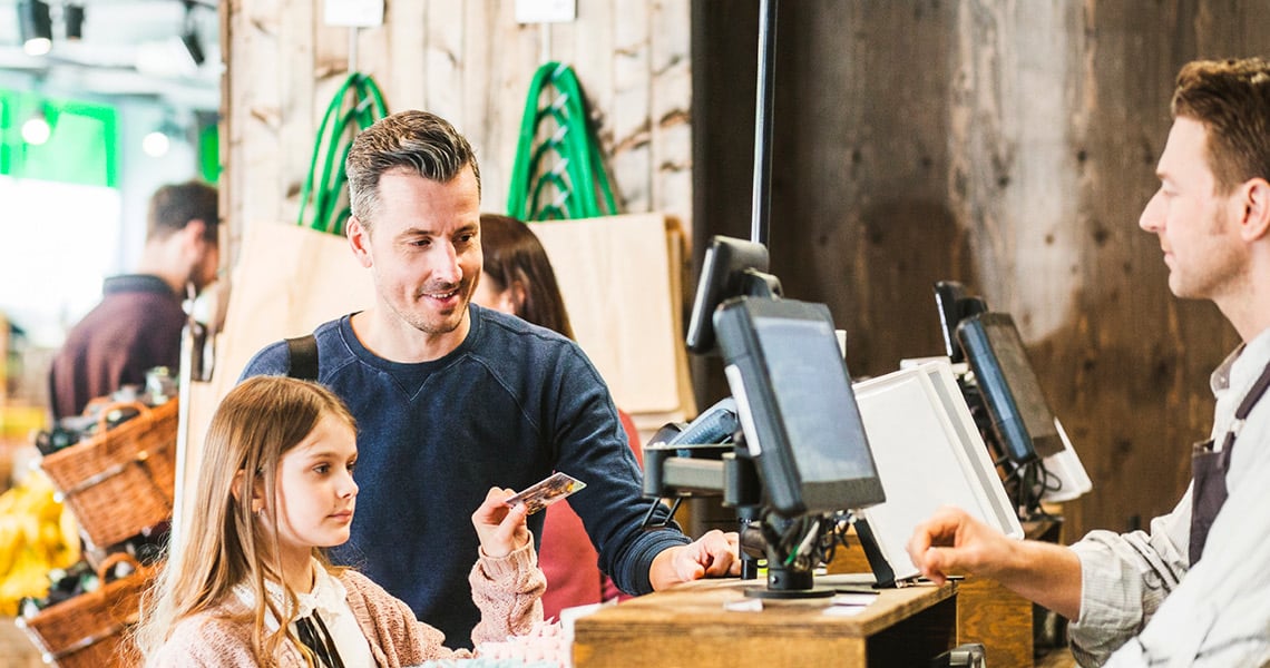 Girl and father pay with card in store